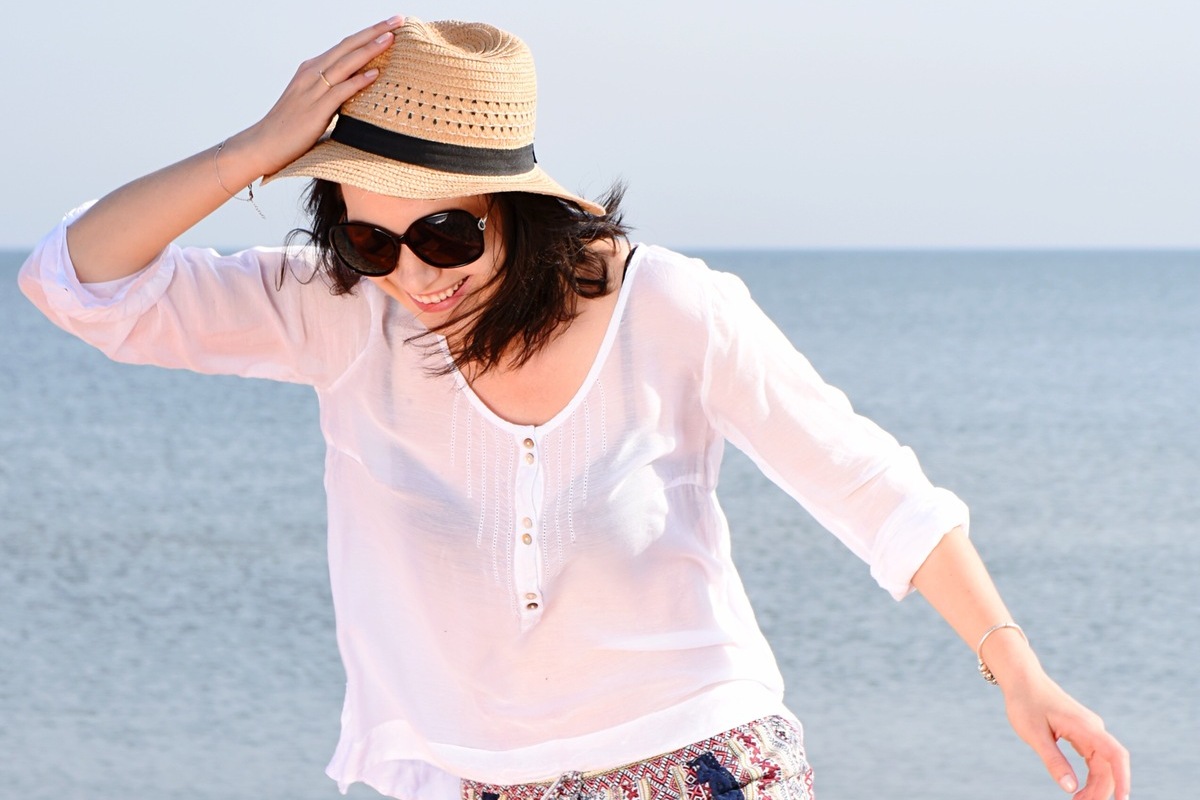 A woman enjoying a bright day beside the sea